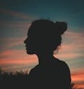 Silhouette of a person against a vibrant sunset sky. Perfect for themes of contemplation and peace.