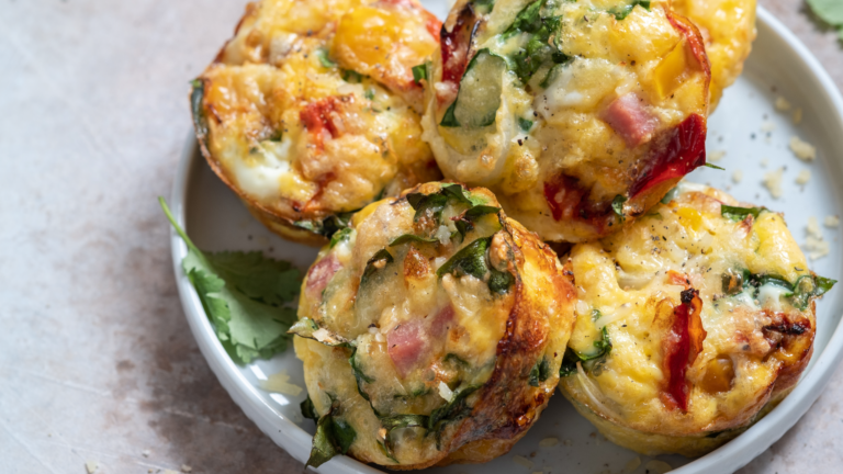 A small stack of delicious-looking egg muffins on a cream plate